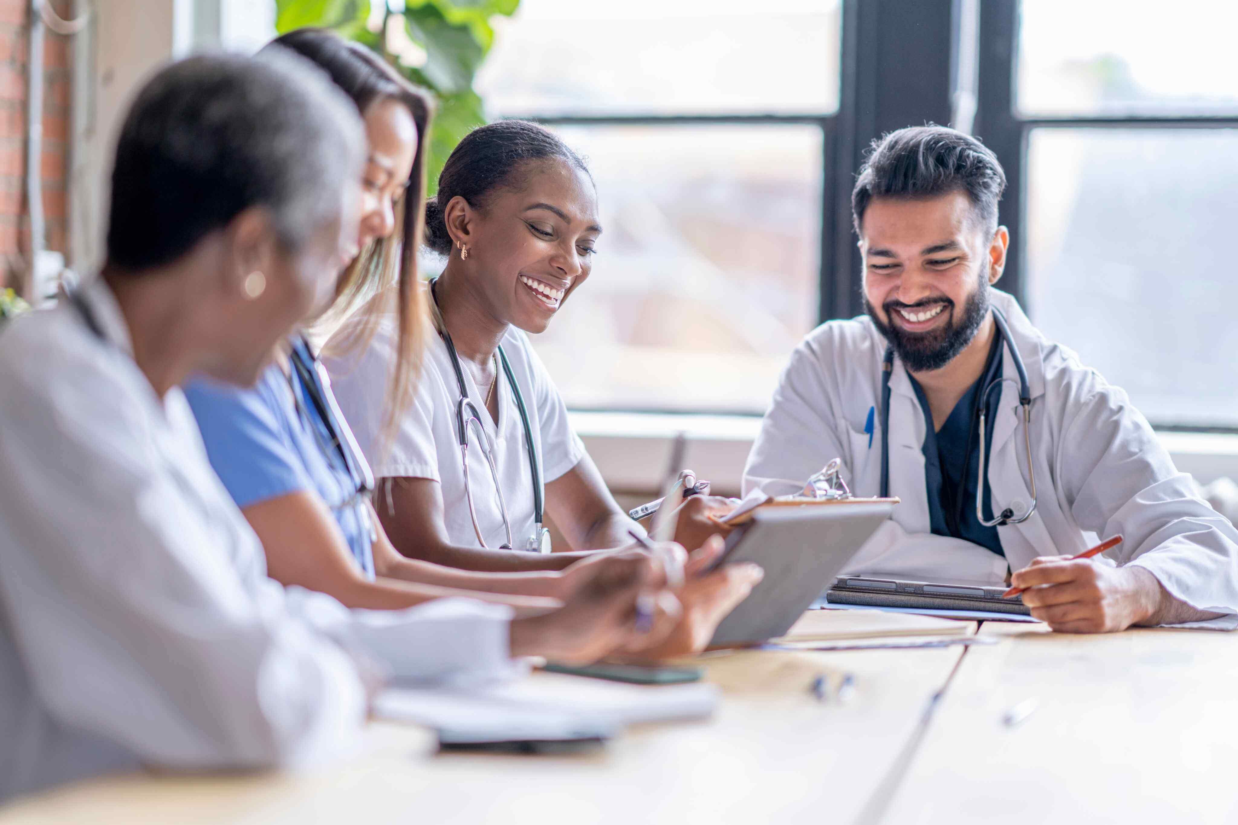 A group of doctors engaged in discussion while seated around a conference table, sharing ideas and insights.